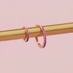 18ct rose gold ruby huggie earrings with claw-set rubies front and back.