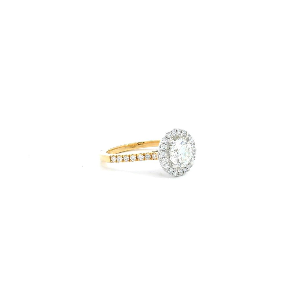 18ct yellow and white gold diamond halo ring featuring a 1.02ct round brilliant cut diamond with a multi-claw halo and diamond-set shoulders.