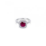 18ct white gold ring featuring a 1.06ct cushion-cut ruby in a four-claw setting with a cushion-shaped diamond halo and claw-set shoulders.