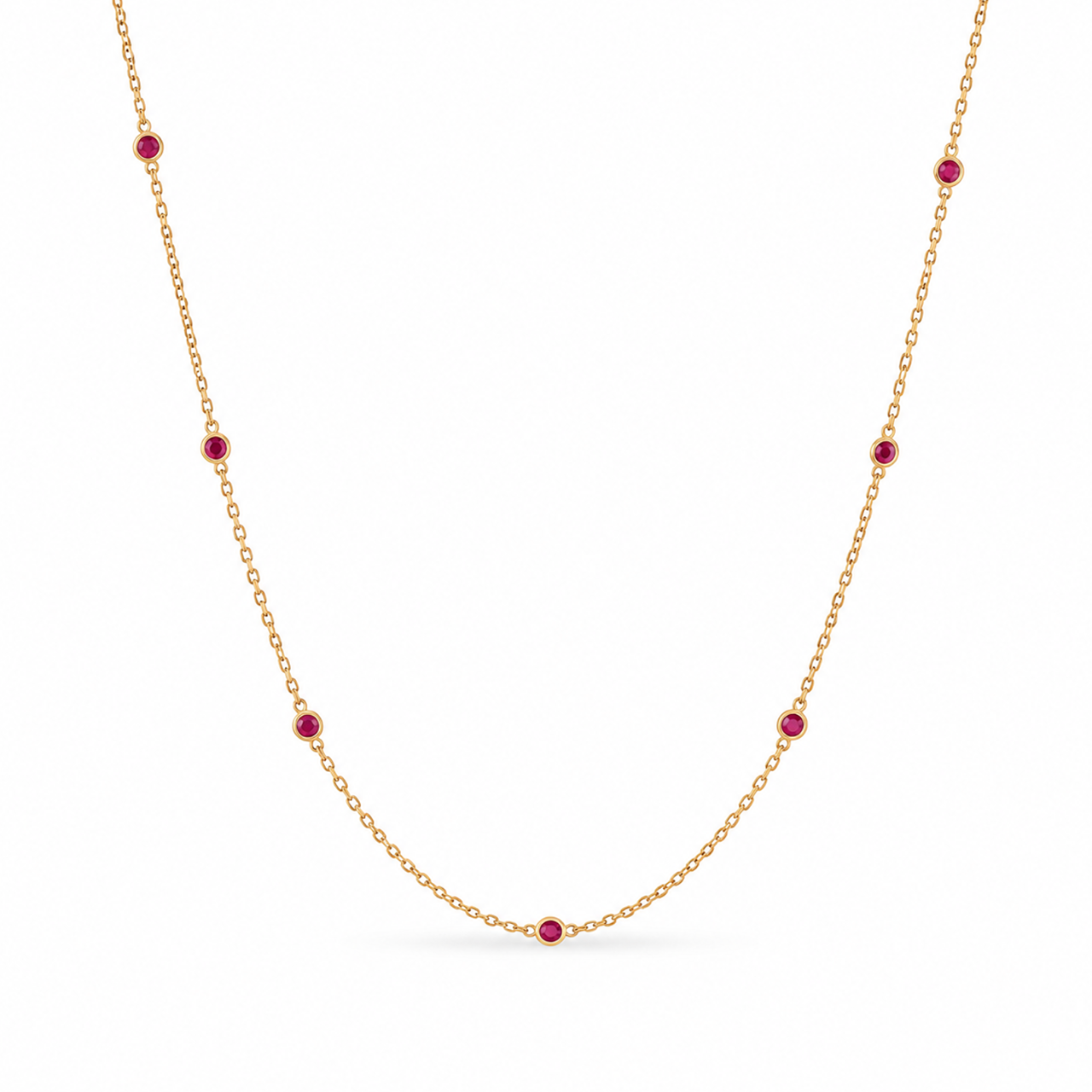 18ct yellow gold ruby station necklet featuring seven round-cut pinkish-red rubies in individual bezel settings along a fine 42cm trace chain.