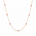 18ct yellow gold ruby station necklet featuring seven round-cut pinkish-red rubies in individual bezel settings along a fine 42cm trace chain.