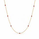 18ct yellow gold ruby station necklet featuring seven round-cut pinkish-red rubies in individual bezel settings along a fine 42cm trace chain.