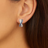 18ct white gold sapphire and diamond earrings featuring a curved “X”-shaped crossover front with alternating sapphire and diamond rows.