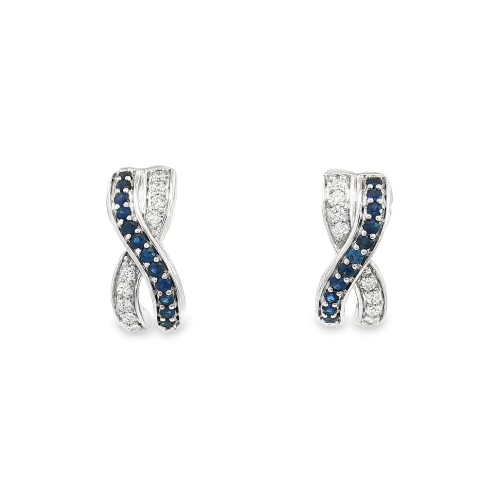 18ct white gold sapphire and diamond earrings featuring a curved “X”-shaped crossover front with alternating sapphire and diamond rows.