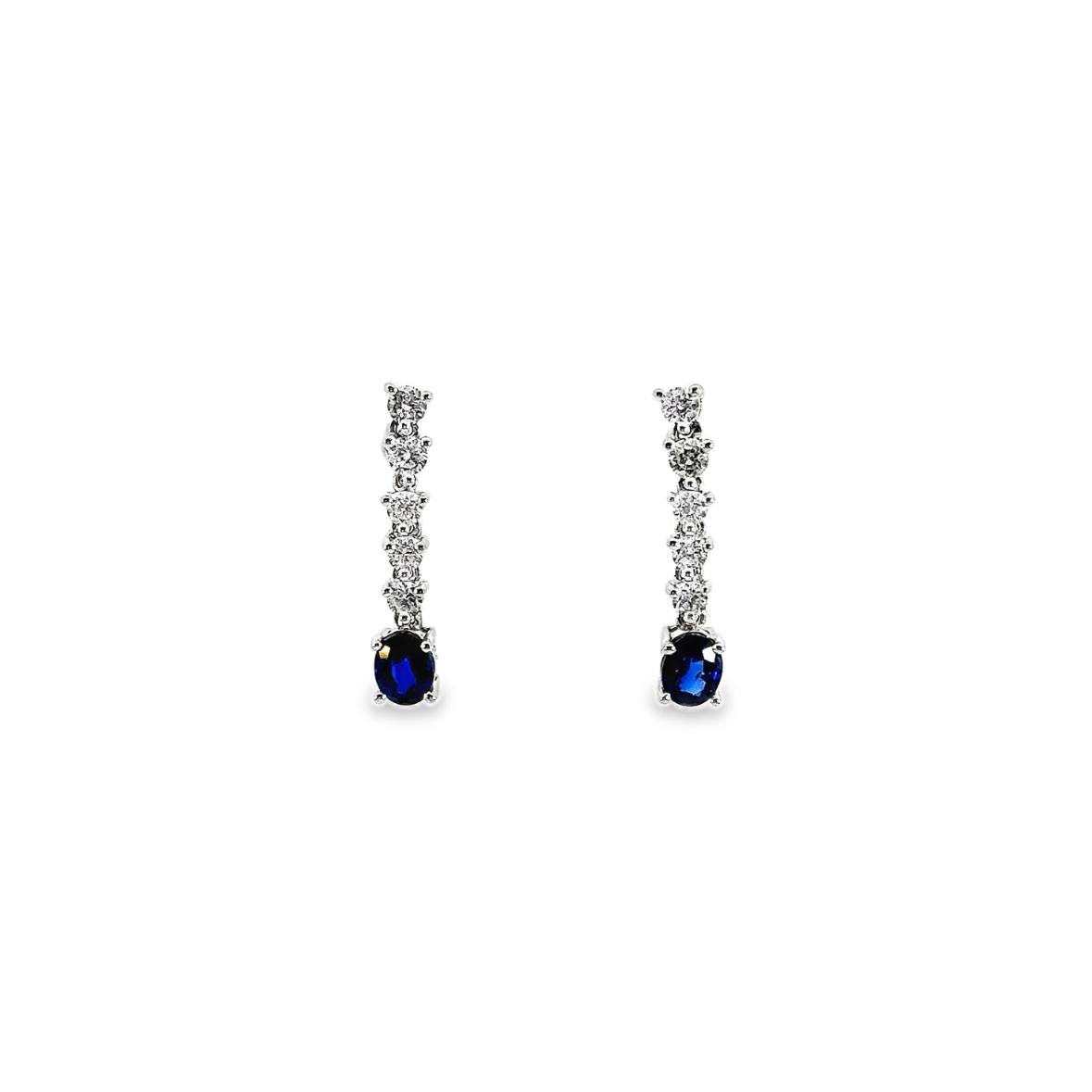 18ct white gold drop earrings with five articulated round brilliant cut diamonds leading to 5x4mm oval-cut sapphire drops, post and butterfly fittings.