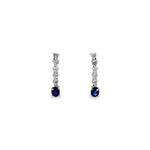 18ct white gold drop earrings with five articulated round brilliant cut diamonds leading to 5x4mm oval-cut sapphire drops, post and butterfly fittings.