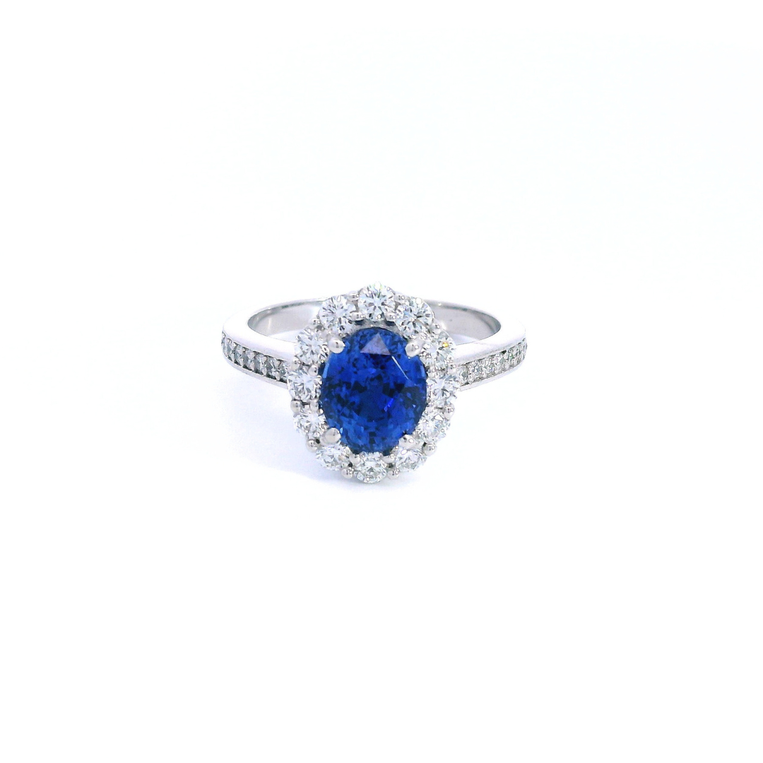 18ct white gold sapphire and diamond halo ring featuring a 2.18ct oval cut sapphire with a diamond halo and bead-set diamond shoulders.