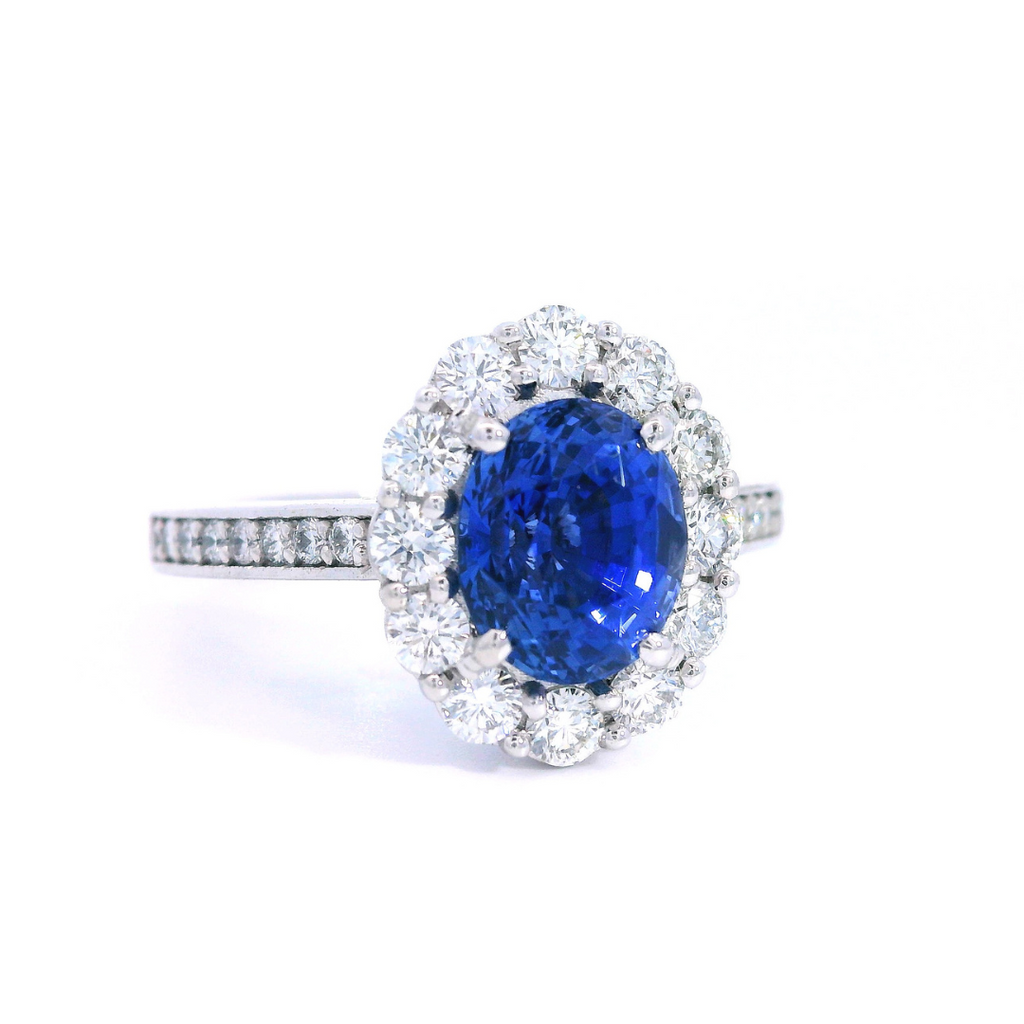 18ct white gold sapphire and diamond halo ring featuring a 2.18ct oval cut sapphire with a diamond halo and bead-set diamond shoulders.