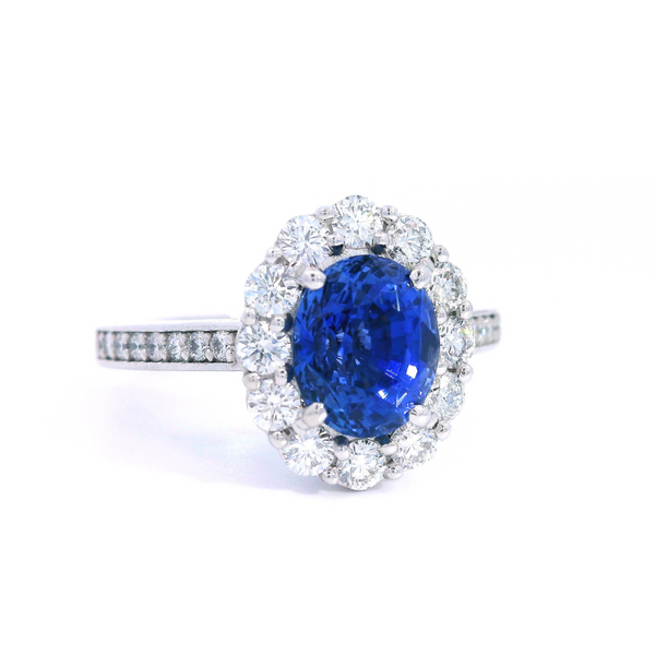 18ct white gold sapphire and diamond halo ring featuring a 2.18ct oval cut sapphire with a diamond halo and bead-set diamond shoulders.