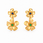 18ct yellow gold double frangipani stud earrings featuring polished flowers with blue sapphire centres and matte flowers with green garnet centres.
