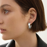 Sterling silver double crossover cuff hoop earrings with polished finish.