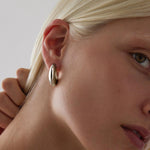 Sterling silver puff cuff style stud earrings with polished finish.