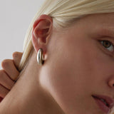 Sterling silver puff cuff style stud earrings with polished finish.