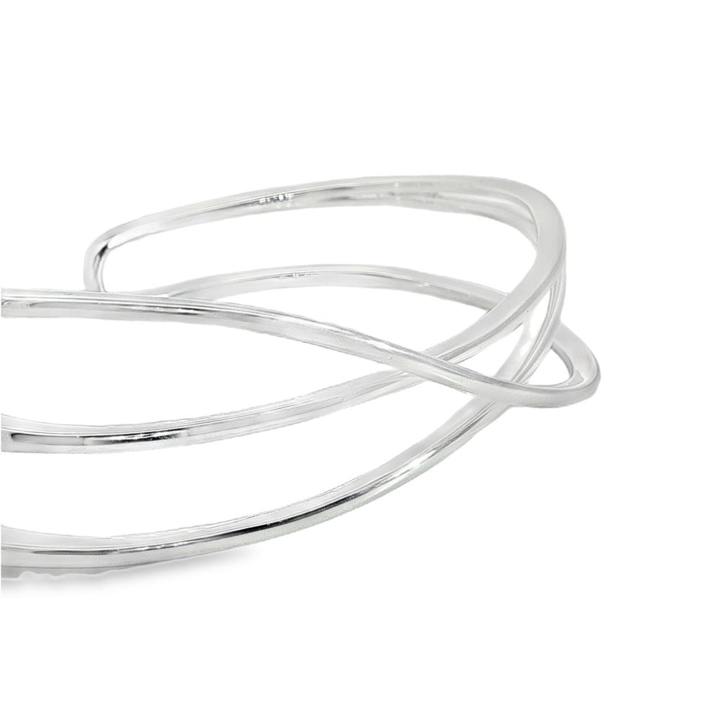 Sterling silver cuff bangle with open triple-strand curved crossover design, polished finish, 22mm wide, 60mm inner measurement.