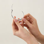 Sterling silver cuff bangle with open triple-strand curved crossover design, polished finish, 22mm wide, 60mm inner measurement.