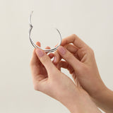 Sterling silver cuff bangle with open triple-strand curved crossover design, polished finish, 22mm wide, 60mm inner measurement.