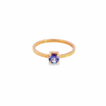 9ct rose gold ring featuring a 5mm round brilliant cut tanzanite in a four-claw setting with a square-profile beaten finish band.
