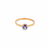 9ct rose gold ring featuring a 5mm round brilliant cut tanzanite in a four-claw setting with a square-profile beaten finish band.