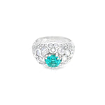 18ct white gold domed ring featuring a teal tourmaline with rose cut and round brilliant cut diamond floral clusters and pavé-set shoulders.