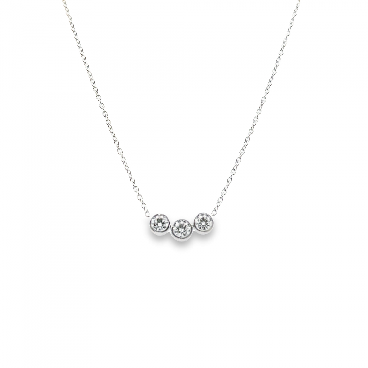 18ct white gold necklace featuring three bezel-set round brilliant cut diamonds in joined settings on a 40cm adjustable trace link chain.