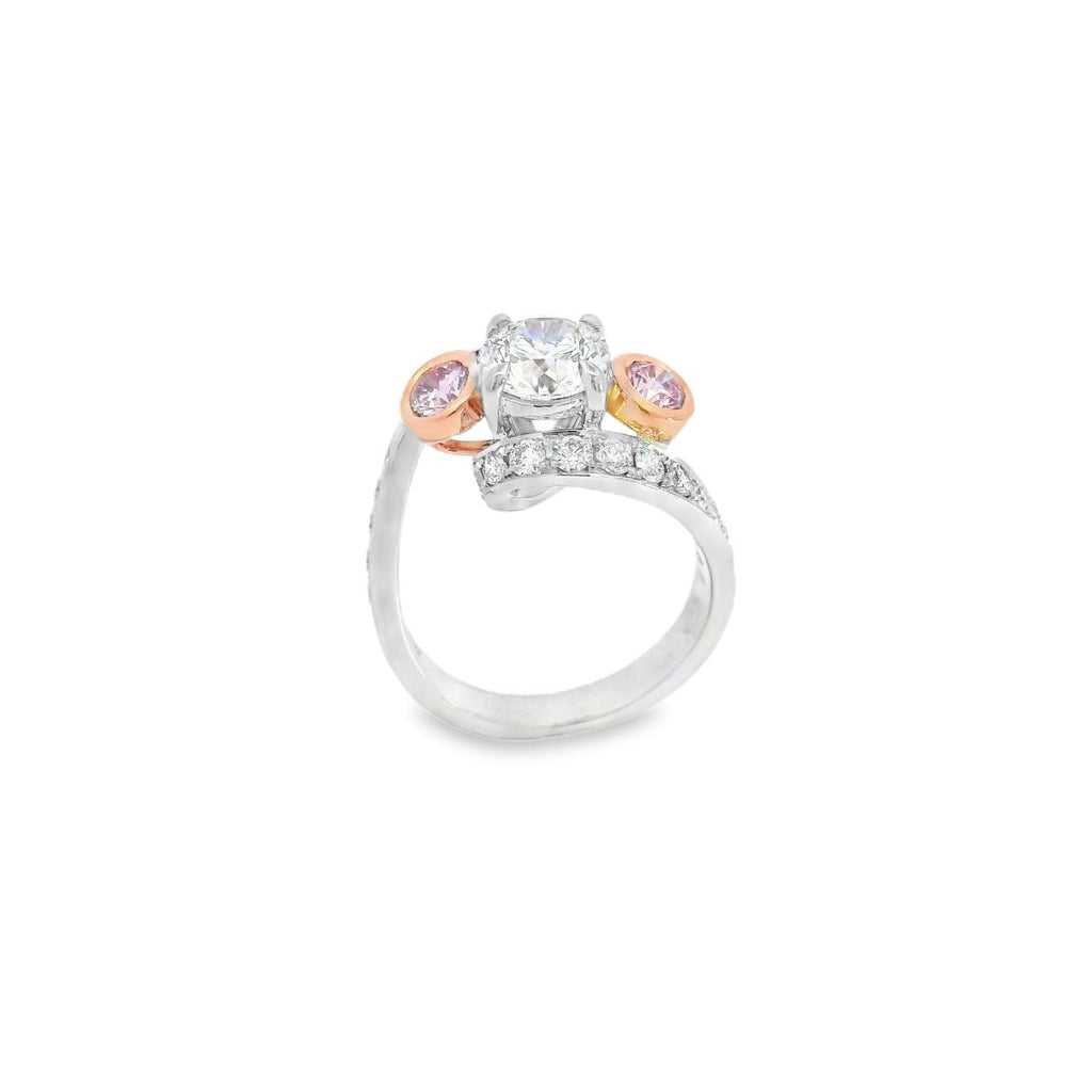 18ct white and rose gold ring featuring a round white diamond centre, two Argyle pink diamond side stones, and bead-set diamond shoulders in a loop design.