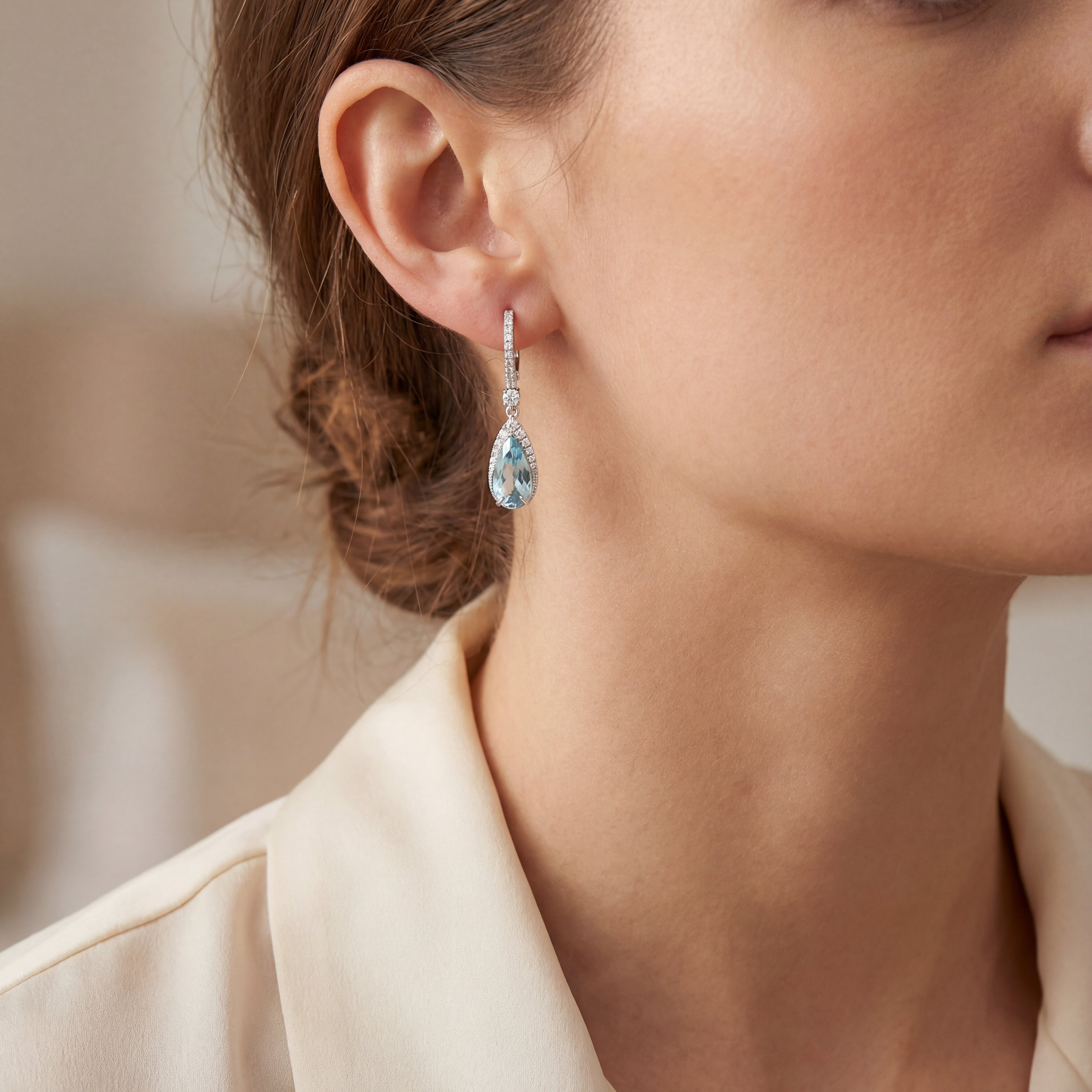 18ct white gold aquamarine and diamond drop earrings with pear cut aquamarines and claw set diamonds.