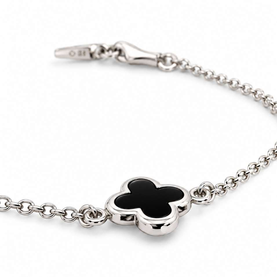 9ct white gold trace link bracelet with small black clover centre.