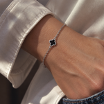 9ct white gold trace link bracelet with small black clover centre.