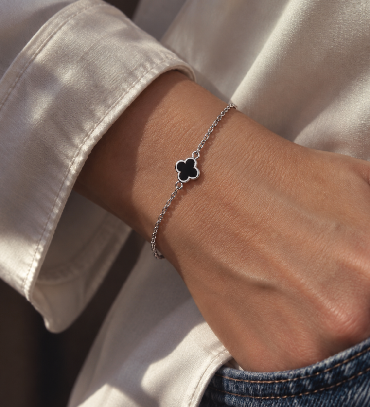 9ct white gold trace link bracelet with small black clover centre.