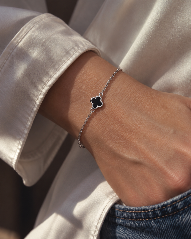 9ct white gold trace link bracelet with small black clover centre.