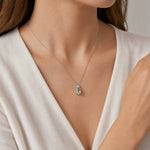 9ct white gold green beryl and diamond pendant with oval green beryl and triangular diamond accent.