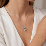 9ct white gold green beryl and diamond pendant with oval green beryl and triangular diamond accent.