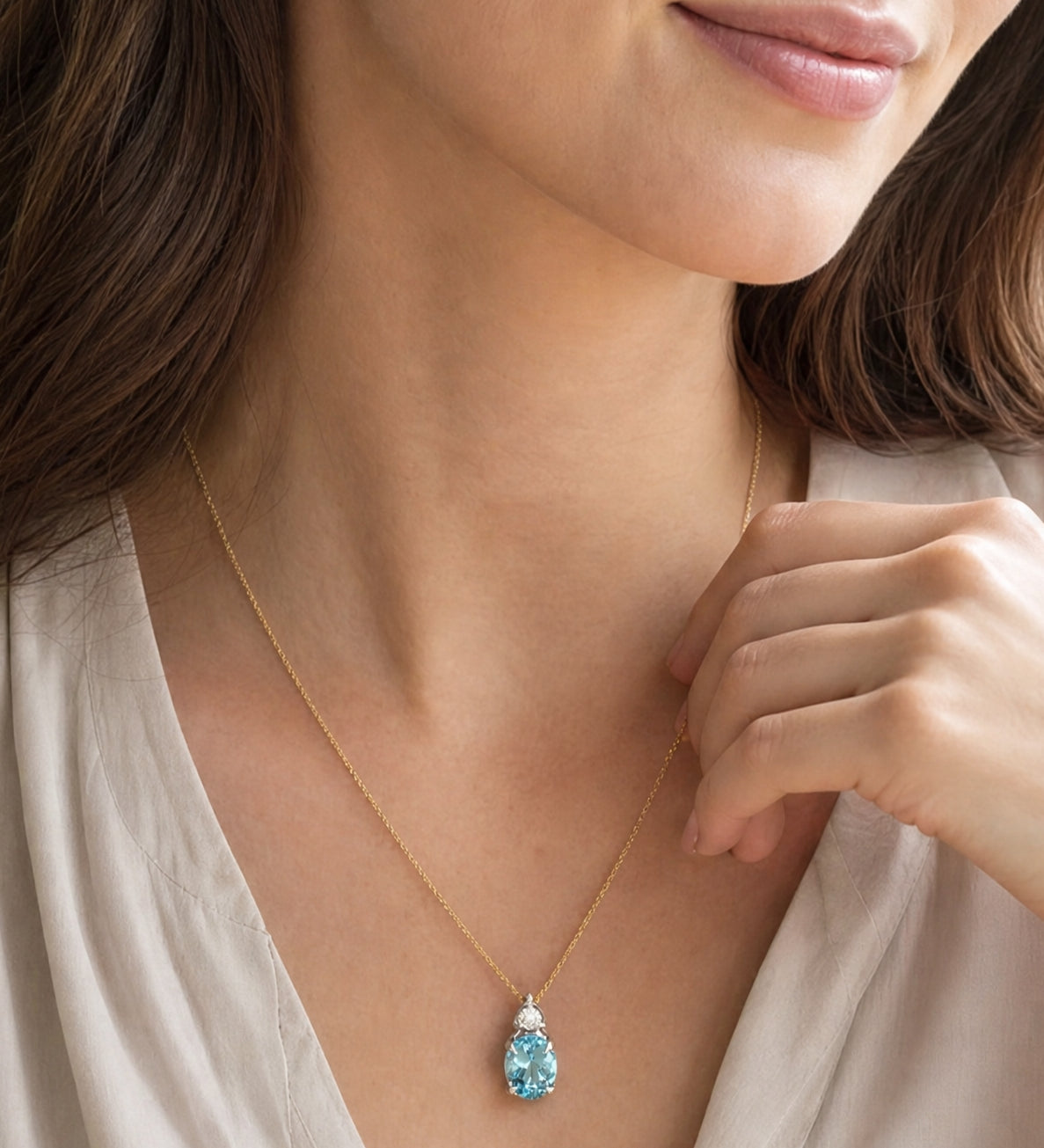 9ct white gold oval aquamarine and diamond pendant with triangular diamond accent.