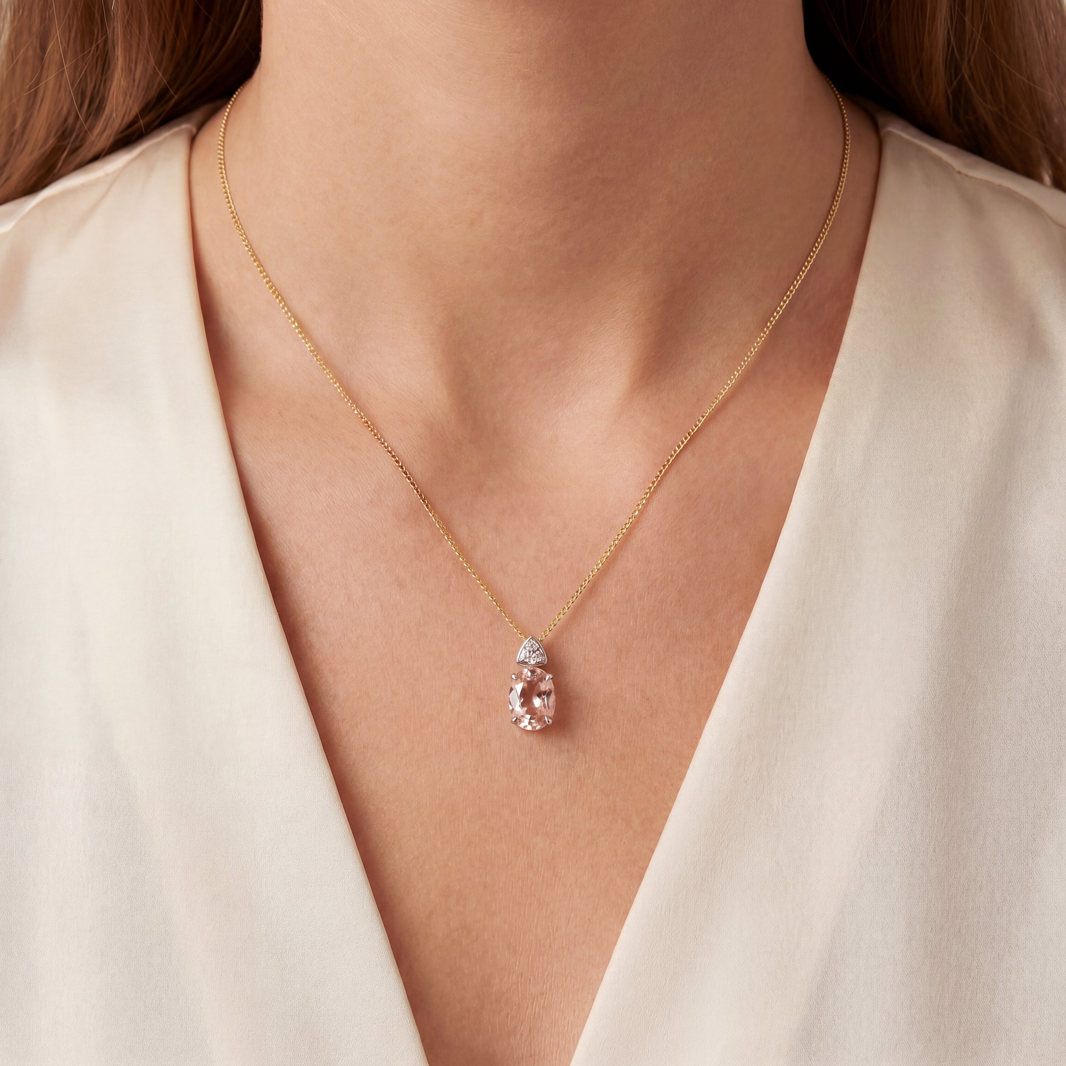 9ct white gold oval morganite and diamond pendant with triangular diamond detail.