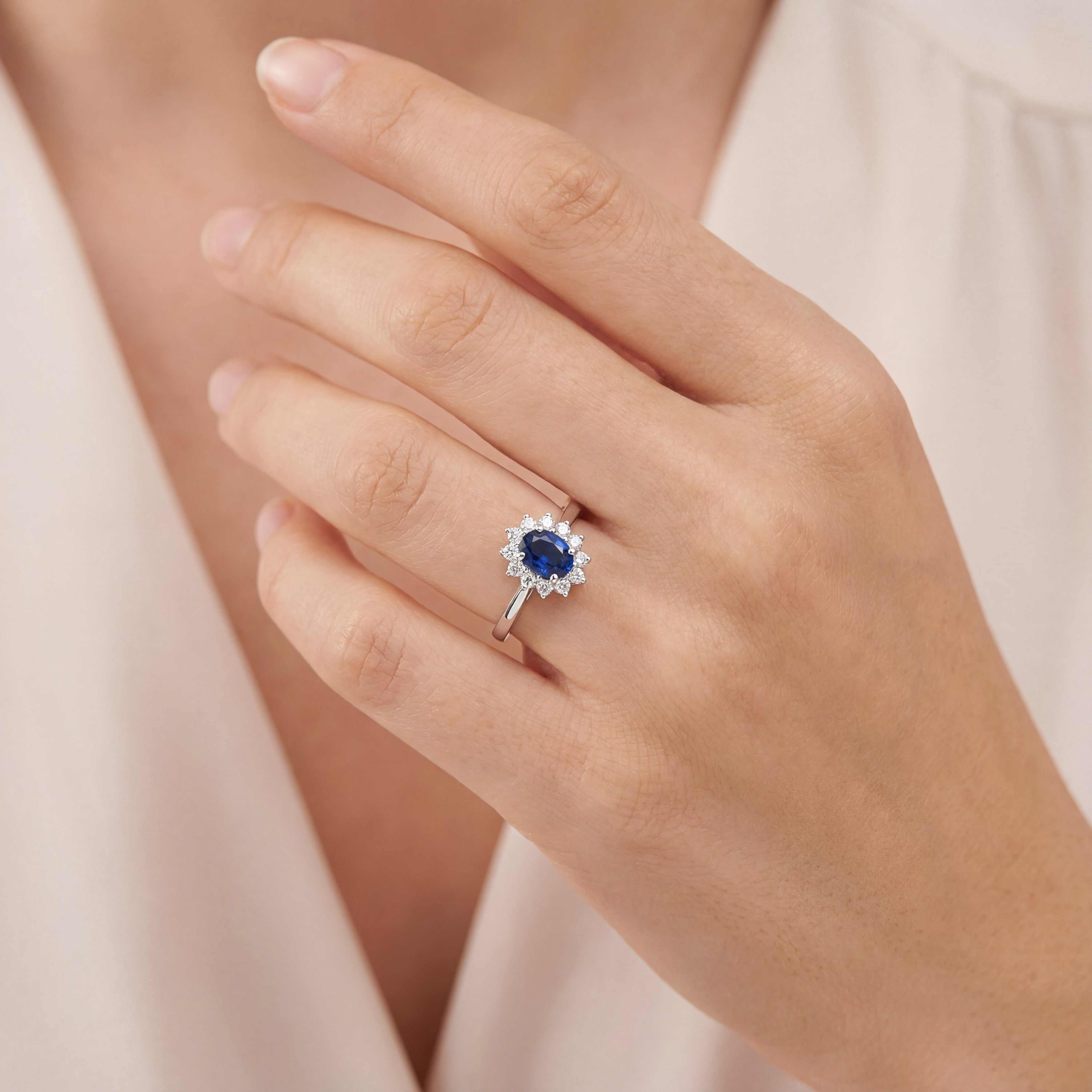 18ct white gold oval sapphire ring with diamond cluster surround.