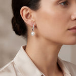 18ct white gold huggie earrings with claw-set diamonds and 11mm South Sea pearl drops.