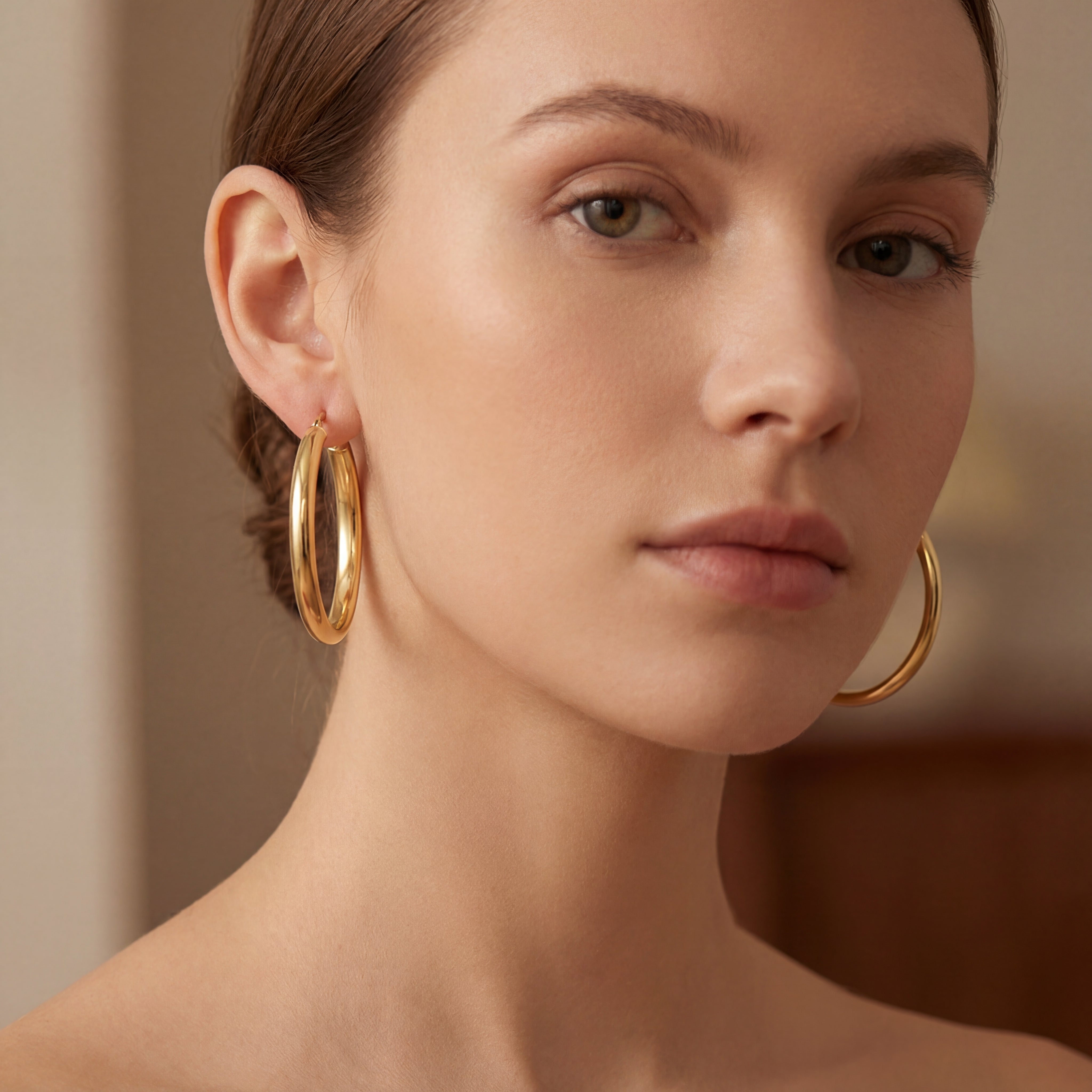 9ct yellow gold 30mm hoop earrings with polished cushion-profile tubing.