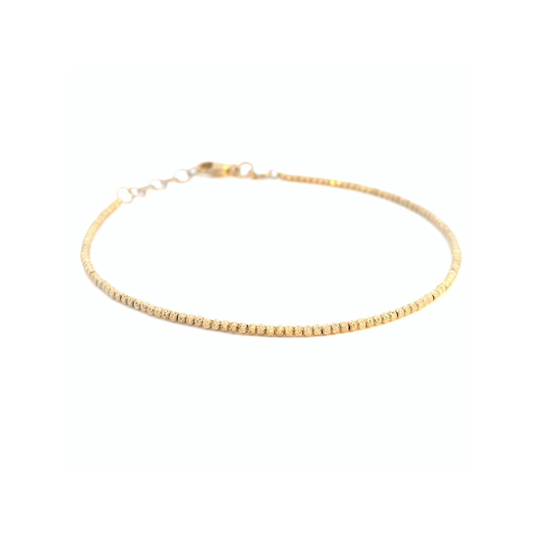 Yellow gold bracelet featuring facetted diamond-cut beads with a secure parrot clasp.