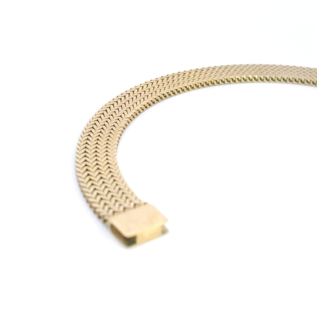 Yellow gold 7.5mm flat herringbone link bracelet with a fancy parrot clasp.