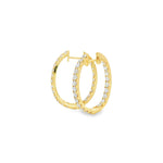18ct yellow gold oval diamond huggie earrings with diamonds along the front and inside back.