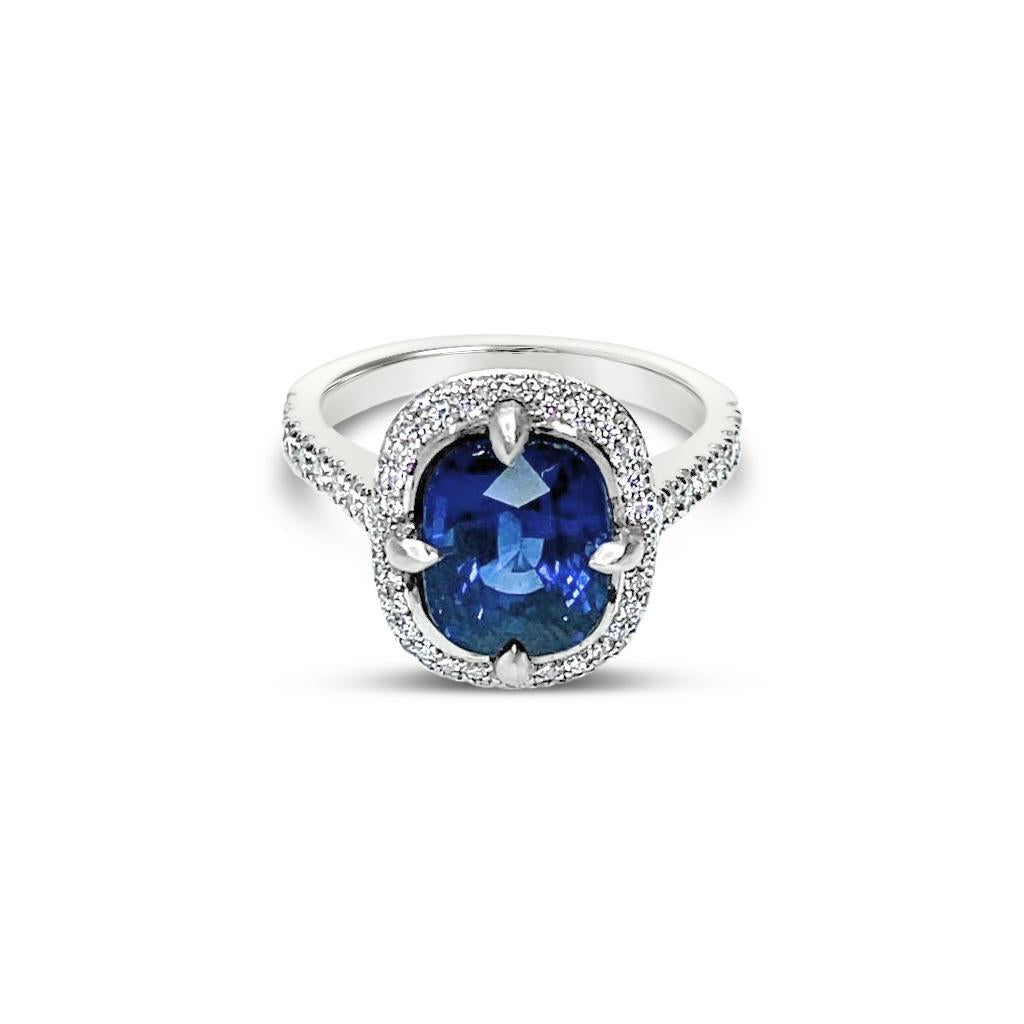 Platinum ring featuring a 4.58ct unheated Ceylon sapphire surrounded by round brilliant cut diamonds totalling 0.42ct in a cluster setting, GSL certified.