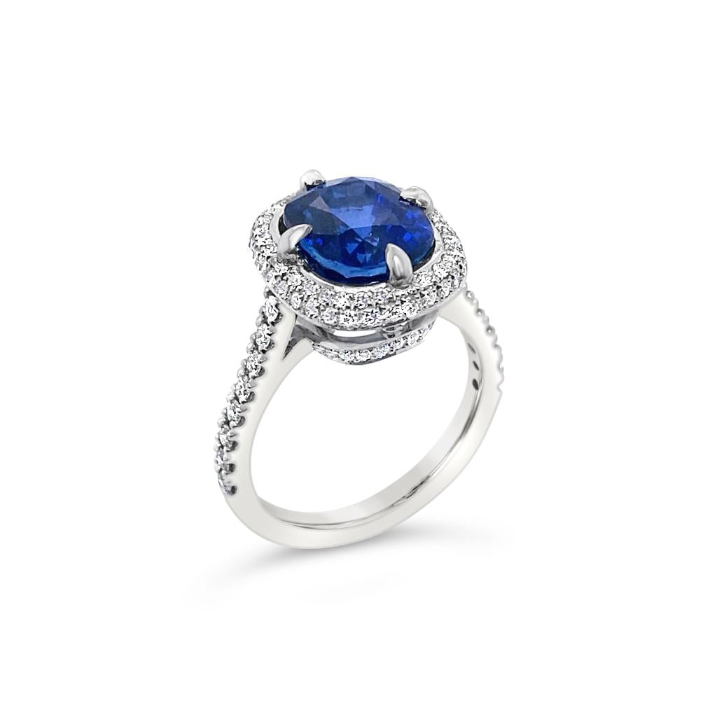Platinum ring featuring a 4.58ct unheated Ceylon sapphire surrounded by round brilliant cut diamonds totalling 0.42ct in a cluster setting, GSL certified.