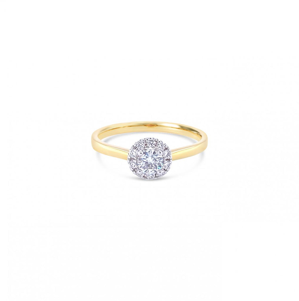 18ct yellow and white gold diamond halo ring featuring a 0.20ct centre diamond with a halo of ten smaller round brilliant cut diamonds.