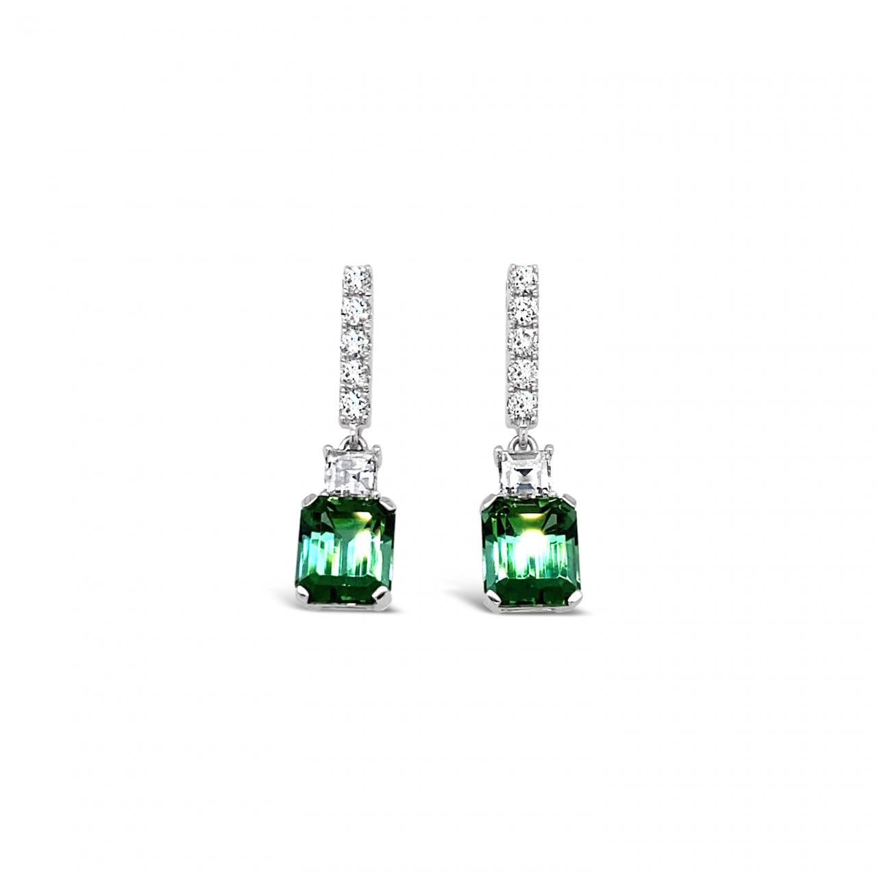 18ct white gold drop earrings featuring emerald-cut green tourmalines with diamond-set bar tops, carré cut accents, and articulated four-claw drops.