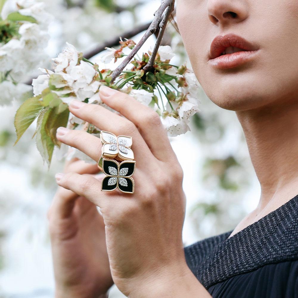 Roberto Coin Princess Flower ring in 18ct rose and white gold featuring mother of pearl petals, diamond detailing, rope edge design, and signature hidden ruby inside the band.