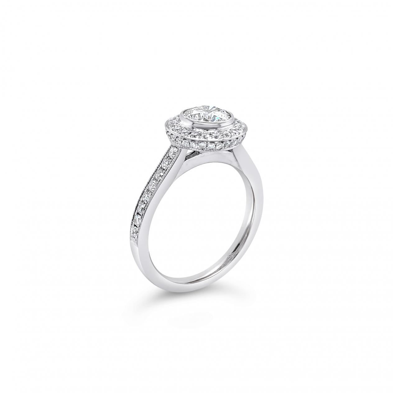 18ct white gold diamond halo ring featuring a 1.00ct round brilliant cut centre diamond with bead-set halo, undercarriage, and shoulders with millgrain finish.