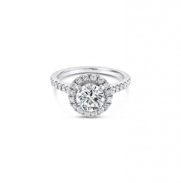18ct white gold diamond halo ring featuring a 1.01ct round brilliant cut centre diamond with a circular diamond halo and claw-set shoulders.