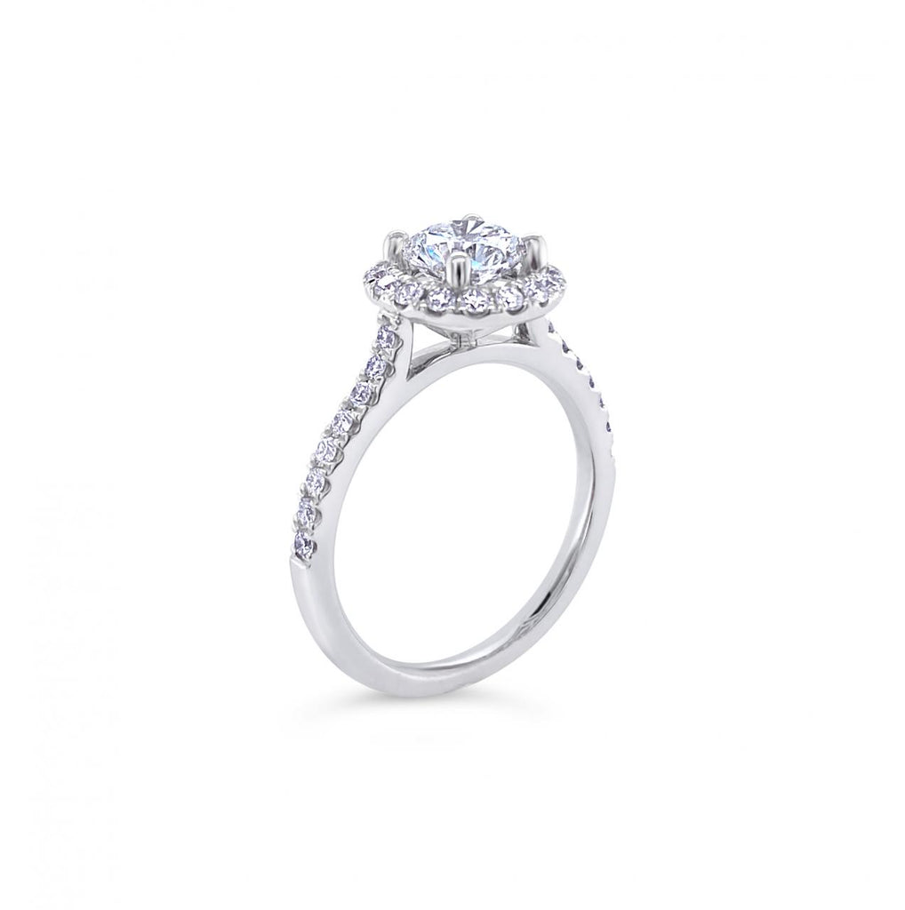 18ct white gold diamond halo ring featuring a 1.01ct round brilliant cut centre diamond with a circular diamond halo and claw-set shoulders.