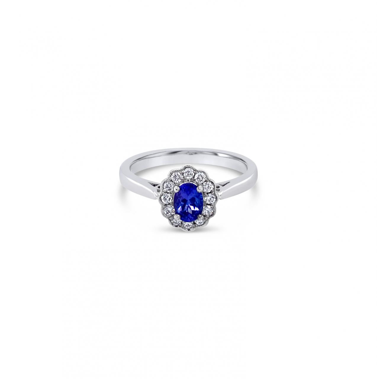 18ct white gold ring featuring a 0.45ct oval cut tanzanite surrounded by twelve round brilliant cut diamonds in an elegant oval cluster design.