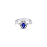 18ct white gold ring featuring a 0.45ct oval cut tanzanite surrounded by twelve round brilliant cut diamonds in an elegant oval cluster design.